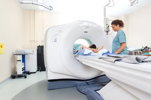 MRI technician assisting a patient laying down in an MRI scanner