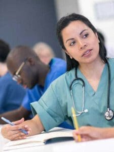 Female nurse sitting at a desk in a classroom