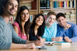 A group of nursing students sitting at a table in a library