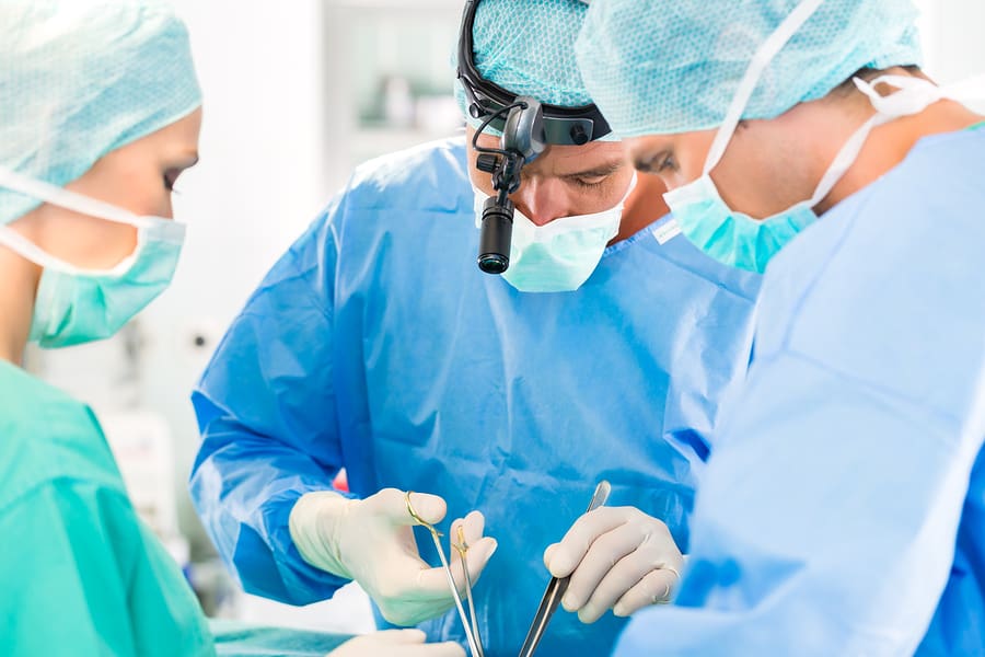 Hospital surgery team in the operating room or Op of a clinic operating on a patient