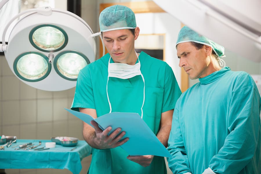 Two surgeons studying file in operating theatre in hospital
