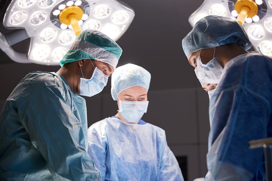 A surgeon and two assistants working in an operating room