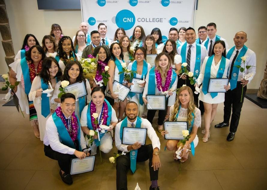 A large group of CNI College graduates holding their diplomas.
