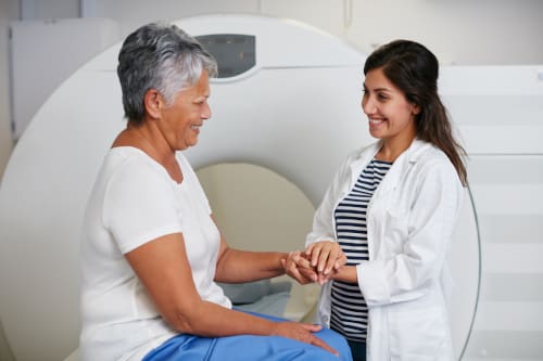 An MRI Technologist talking to a patient getting ready for an MRI