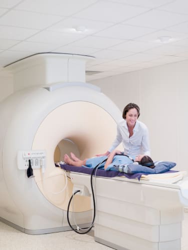 MRI Tech talking to a patient as they get ready for an MRI.