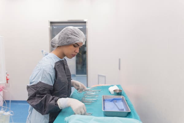 Surgical Technologist in an operating room setting up medical instruments