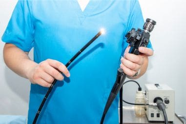 A surgical technician holding an endoscope