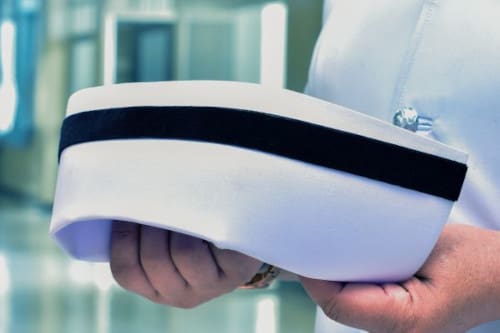 A nurse holding a nurse's cap