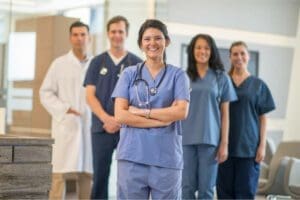 A group of 5 nurses standing together and looking at the camera