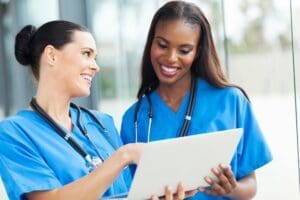 Two nurses looking at a laptop