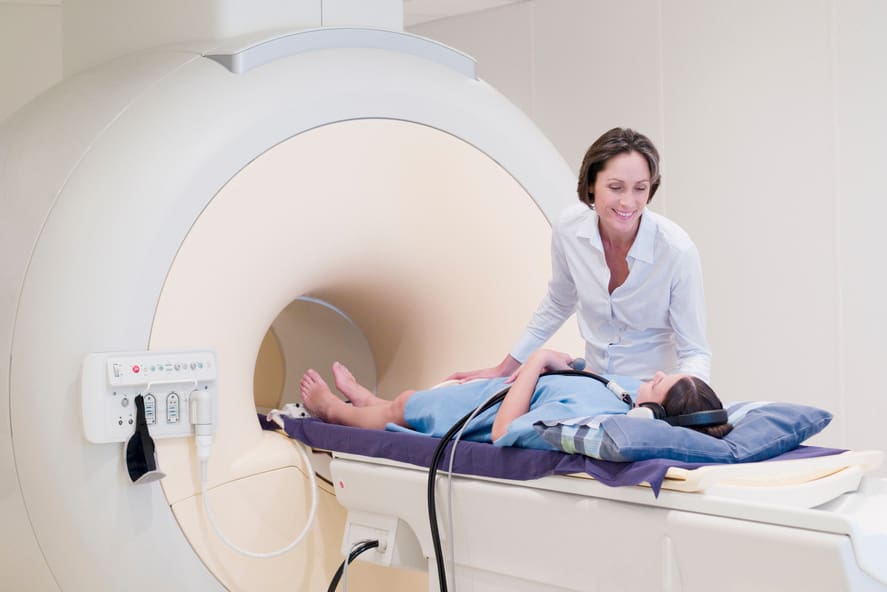 An MRI Technologist working with a patient on a MRI machine