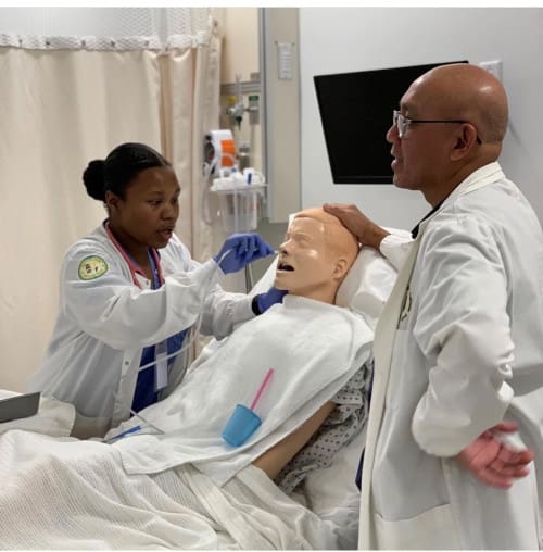 A nursing student practicing on a dummy in the CNI skills lab