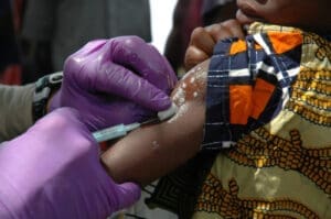A nurse giving a child a vaccine in rural Africa