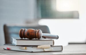 A gavel sitting on top of several books