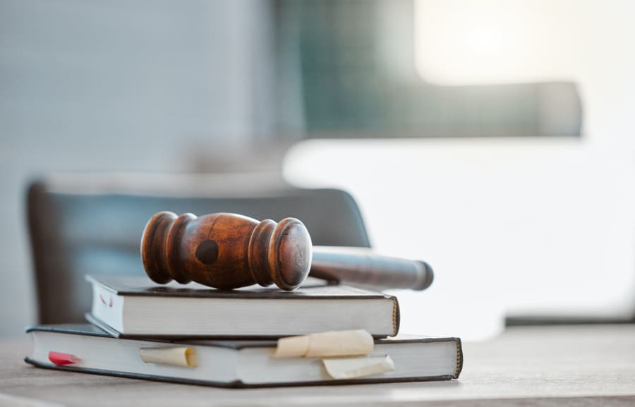 A gavel sitting on top of several books